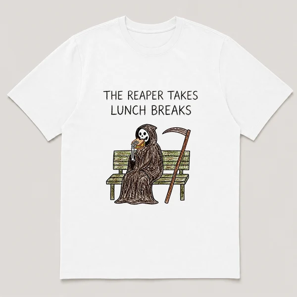 Front view of a White Tee printed with cloaked reaper eats a sandwich on a park bench with its scythe leaning nearby and the caption THE REAPER TAKES LUNCH BREAKS