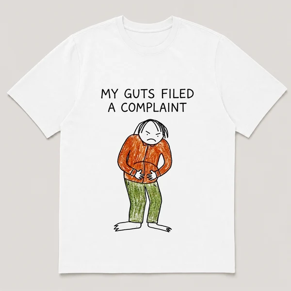 Front view of a White Tee printed with a guy clutches his stomach and glares down at his own belly and the caption MY GUTS FILED A COMPLAINT