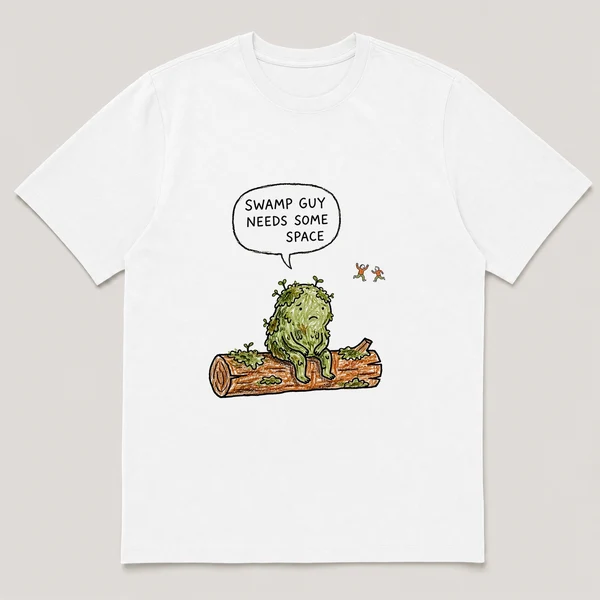 Front view of a White Tee printed with mossy creature sits alone on a log while two kids play far in the distance and the caption SWAMP GUY NEEDS SOME SPACE