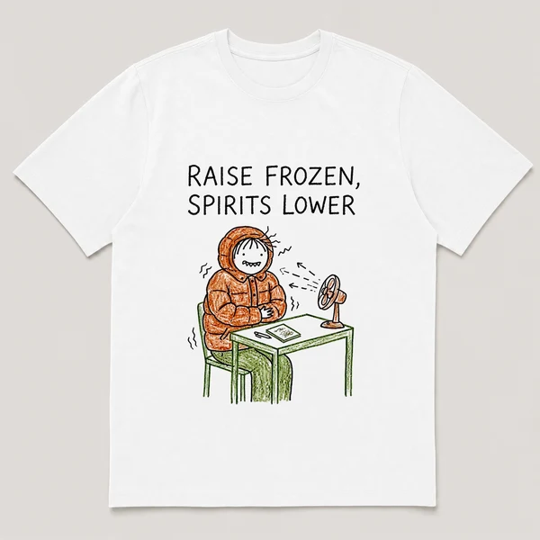 Front view of a White Tee printed with guy in a winter coat shivers at his desk while a small fan blows on him and the caption RAISE FROZEN, SPIRITS LOWER