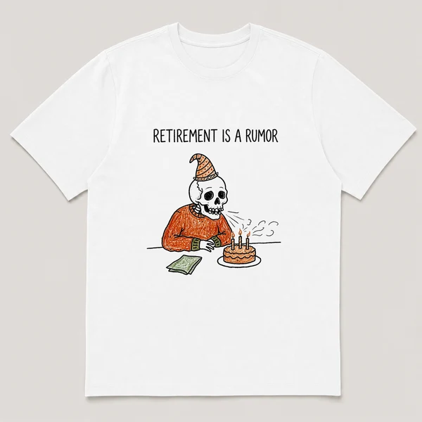 Front view of a White Tee printed with old skeleton in a party hat blows out candles on a small cake at a desk and the caption RETIREMENT IS A RUMOR